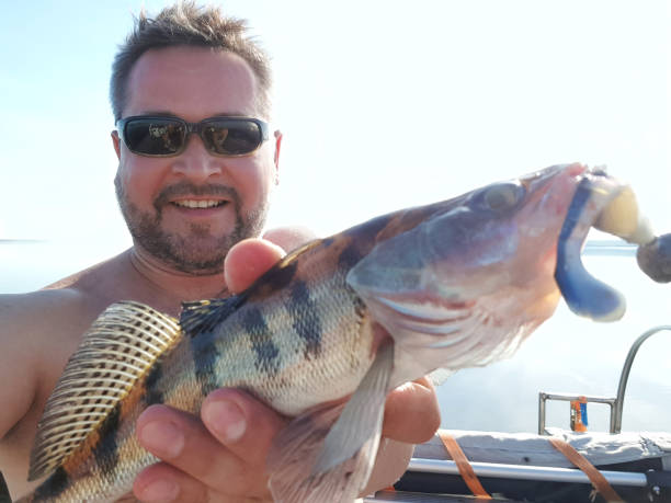 istock Happy man with a fish on a fishing trip. 1027174666