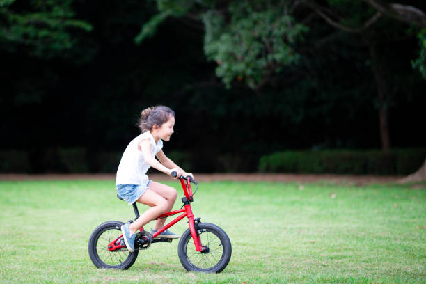istock Girl riding a bicycle on the lawn 1027182568