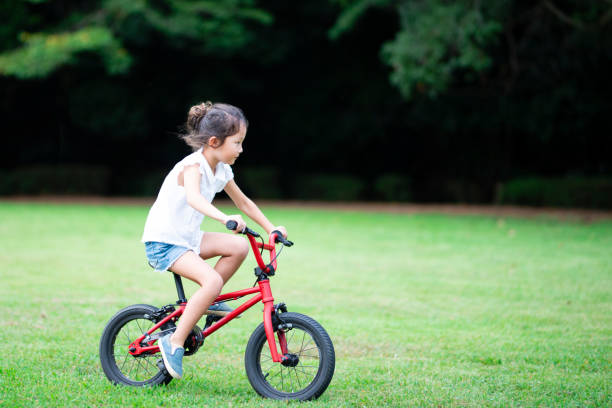 istock Girl riding a bicycle on the lawn 1027182640