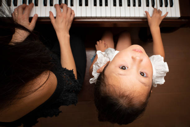 istock Girl playing piano with mother 1027182734