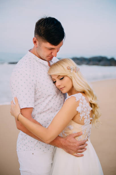 istock newlyweds standing and hugging on tropical beach 1027182874