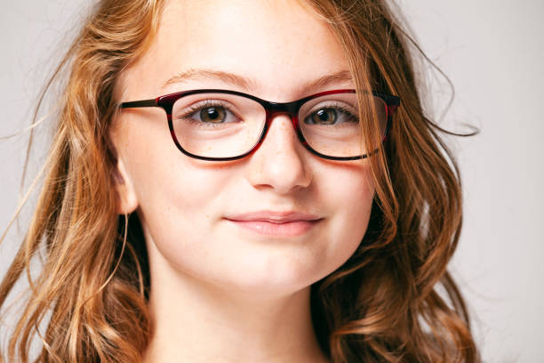 portrait of a 10 years old pretty girl  -  child teenager face hair beauty fun eyes freckles glasses - 10 11 years cheerful happiness fun imagens e fotografias de stock