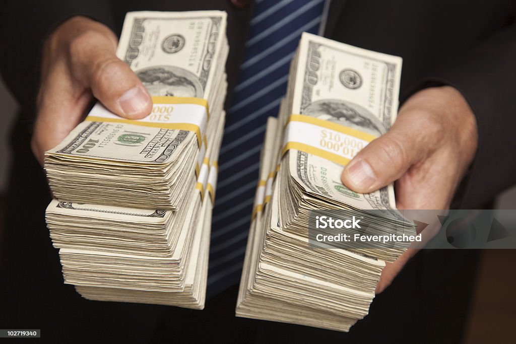 Businessman Handing Over Stacks of Money  Large Group Of Objects Stock Photo