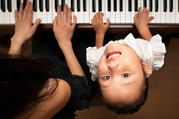 istock Girl playing piano with mother 1027198416