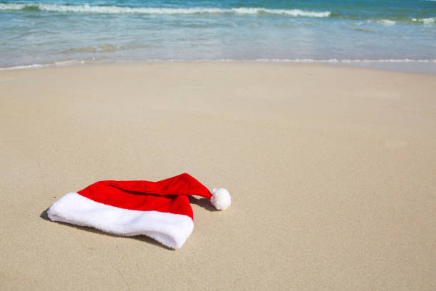 istock Santa Claus hat on caribbean beach. Christmas background 1027201570