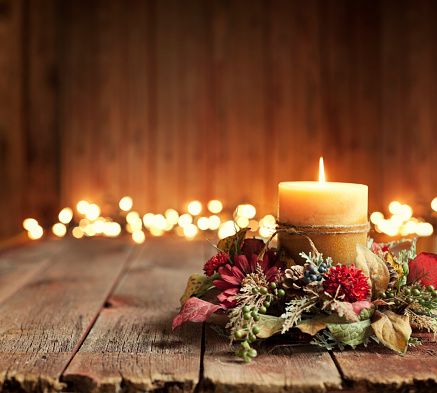 Christmas holiday elegant candle set against Christmas lights and old textured and toned wood background