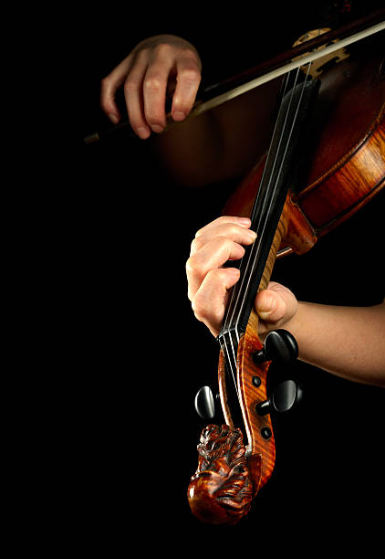 istock Musician playing violin isolated on black 102720370