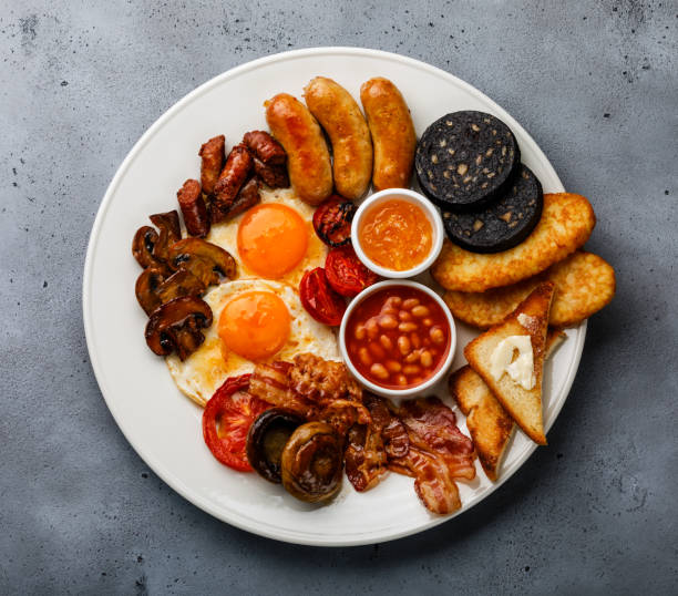 istock Full fry up English breakfast with fried eggs, sausages, bacon, black pudding, beans and toasts 1027211274