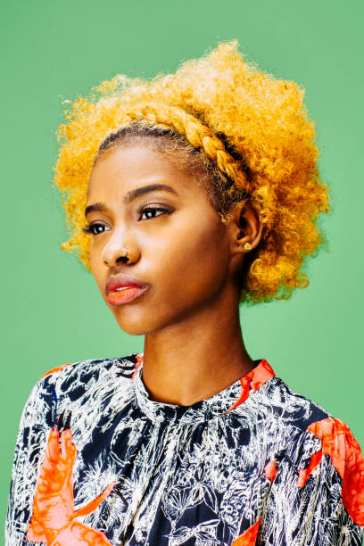 istock Young girl with bleached curly hair looking off camera 1027211656