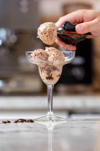 istock Man serving chocolate ice cream into the glass 1027214864