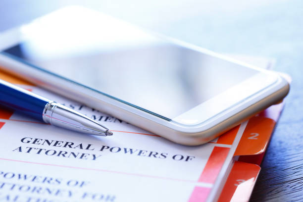 istock Ballpoint Pen And Mobile Phone Rest On Top Of Powers Of Attorney Documents 1027216268