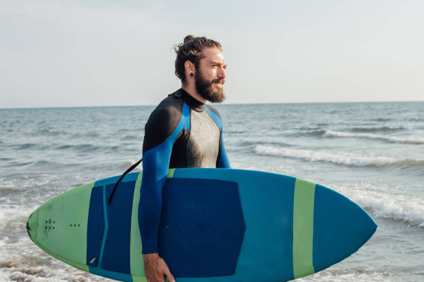 istock Smiling young surfer at the beach 1027223560