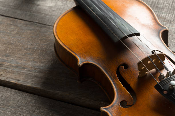 istock Violin on a wooden textured table 1027238250