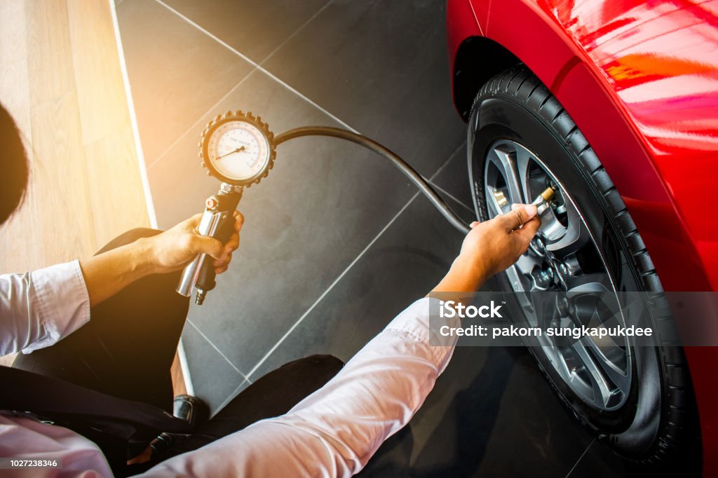 Asian man car inspection Measure quantity Inflated Rubber tires car.Close up hand holding machine Inflated pressure gauge for car tyre pressure measurement for automotive, automobile image Tire - Vehicle Part Stock Photo