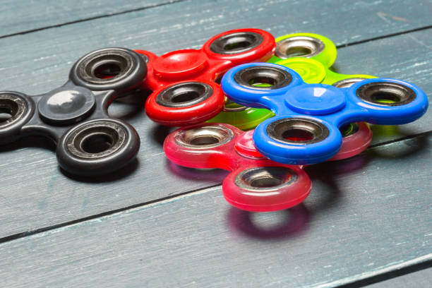 istock fidget hand spinner stress relieving toy on a wooden background 1027238356