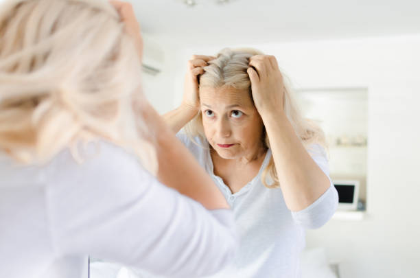 istock Senior woman checking her hair 1027241586
