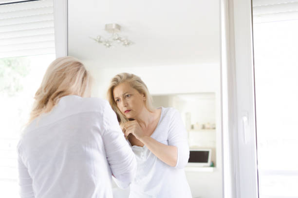 istock Woman looking for grey hair 1027241632