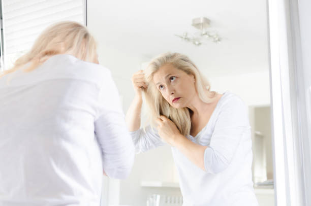 istock Woman looking hair in a mirror 1027241648