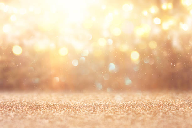 blurred abstract photo of light burst among trees and glitter golden bokeh lights