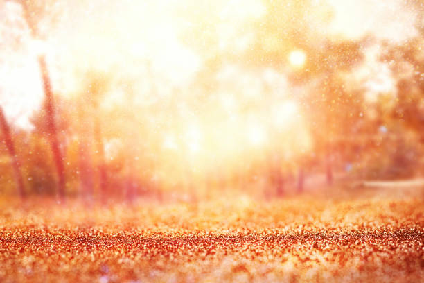 istock blurred abstract photo of light burst among trees and glitter golden bokeh lights. 1027242550