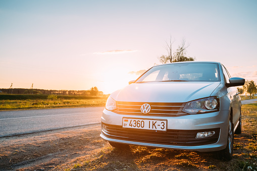 Gomel, Belarus - May 16, 2017: VW Volkswagen Polo Vento Sedan Car Parking Near Asphalt Country Road In Sunny Sunset. Sunlight Above Road In Sunrise.