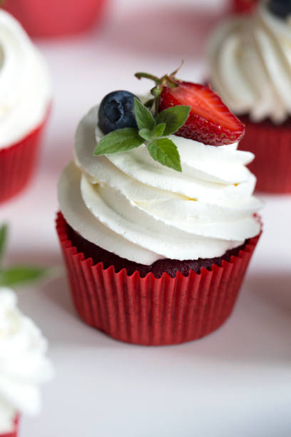istock cupcakes with colored berries. Colorful cupcakes with buttercream and fresh berries 1027243008
