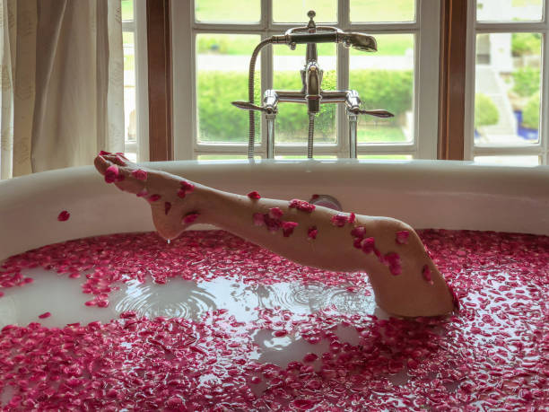 istock Woman relaxes in a rose petal bath in a spa. 1027246146