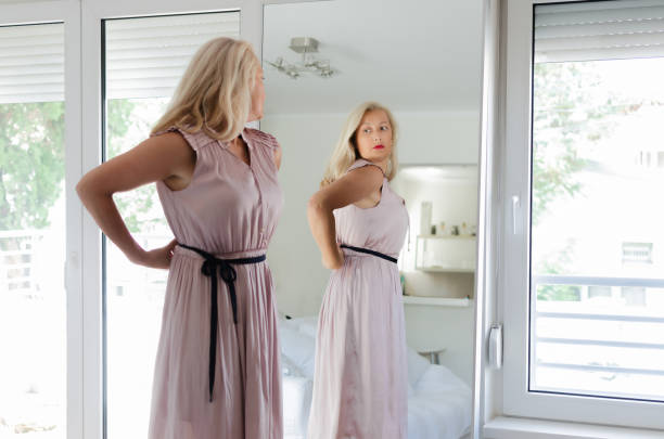 femme debout en robe en face du miroir - mirror women dress looking photos et images de collection