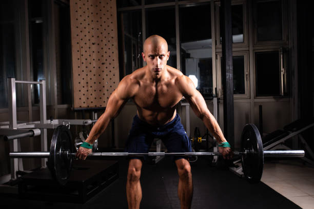 istock Bald shirtless man lifting weights in the gym 1027257210