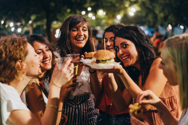 istock Happy friends having fun together, eating hamburger and drinking beer 1027258282