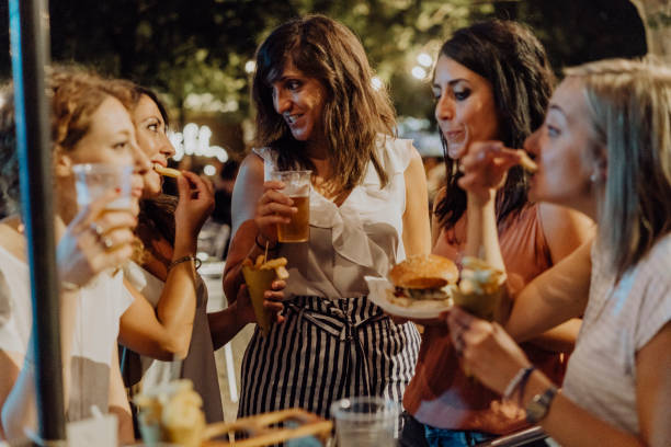 istock Happy friends having fun together, eating hamburger and drinking beer 1027258290