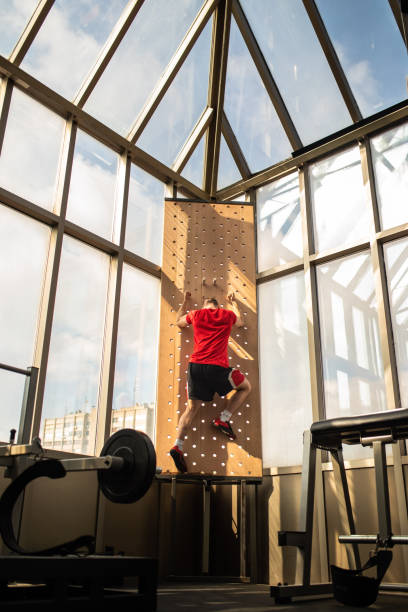 istock Young man climbing wooden wall in the gym 1027258486