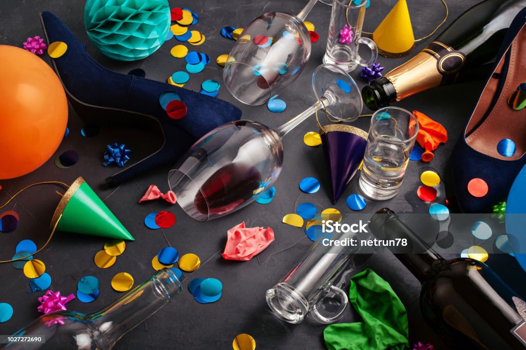 Vue de dessus tourné d’après une célébration de la fête avec le verre des bouteilles vides, vin, fille chaussures et décoration de fête - Photo de Fête libre de droits