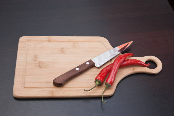 istock red chili peppers and knife on the kitchen table 1027284560