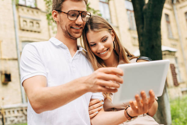 istock happy young couple using tablet together near old building 1027284888