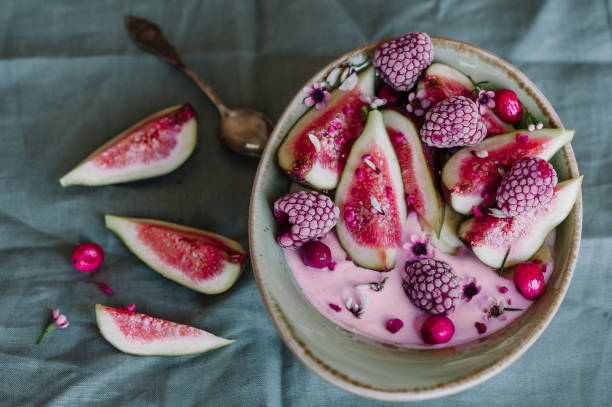 Healthy breakfast bowl with yogurt, fresh figs and frozen berries