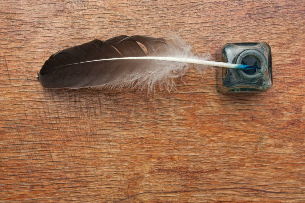istock quill pen in a glass inkwell on  wooden table 1027292968