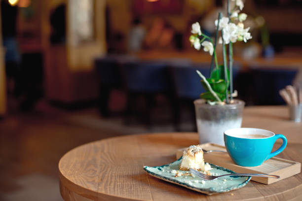 Blue coffee cup baked fruit pie on wooden tray over modern cafe iterior.