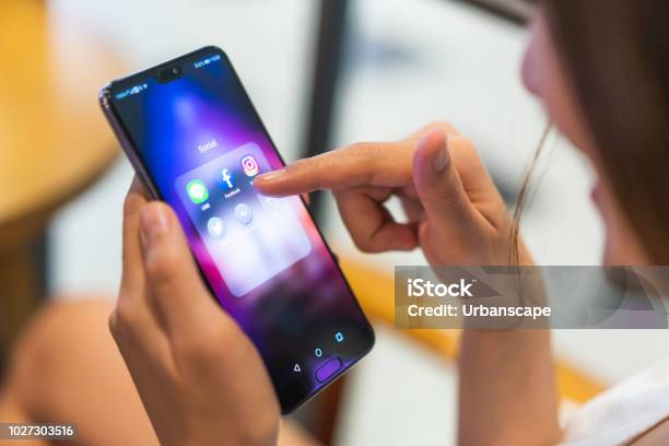 Asian Woman Using Social Media Application On Huawei P20 Pro Smartphone Pointing At Facebook App Illustrative Editorial Content Stock Photo - Download Image Now