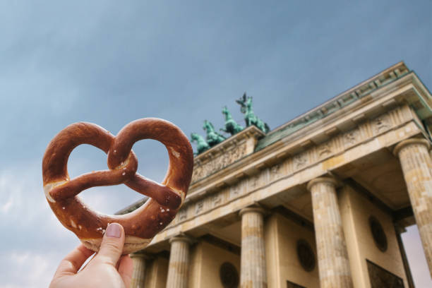 uma menina ou uma mulher está segurando um pretzel alemão tradicional - german culture people women germany - fotografias e filmes do acervo