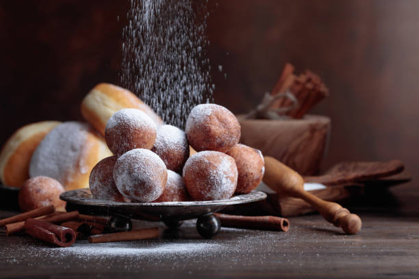 istock Sweet donuts with cinnamon sticks powdered with sugar. 1027314610