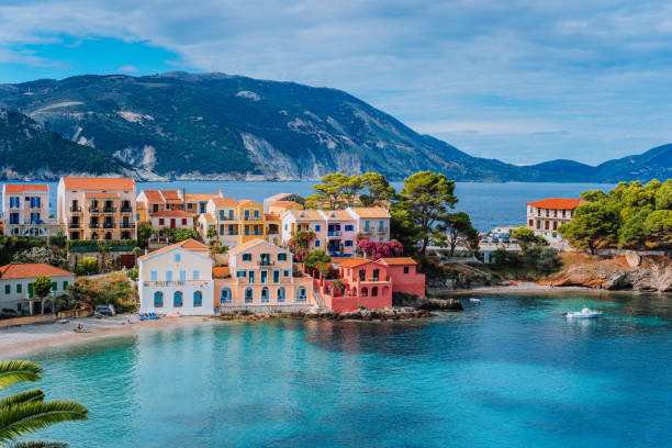 Beautiful panoramic view of Assos village with vivid colorful houses near blue turquoise colored and transparent bay lagoon. Kefalonia, Greece Beautiful panoramic view of Assos village with vivid colorful houses near blue turquoise colored and transparent bay lagoon. Kefalonia, Greece. greece stock pictures, royalty-free photos & images