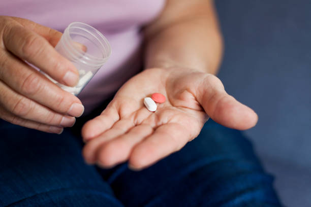 istock senior woman drinking pills 1027338670