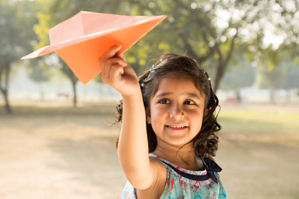 istock Girl playing with paper airplane - Stock image 1027339010
