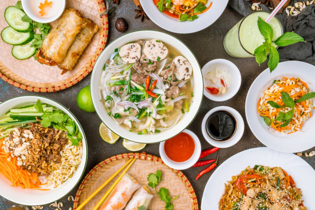 Assorted asian dinner, vietnamese food. Pho ga, pho bo, noodles, spring rolls stock photo