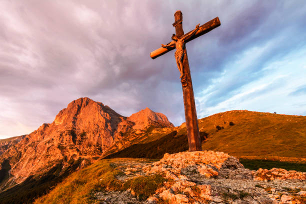 An Evocative Religious Cross on the Mountain Peak at the Sunrise Time