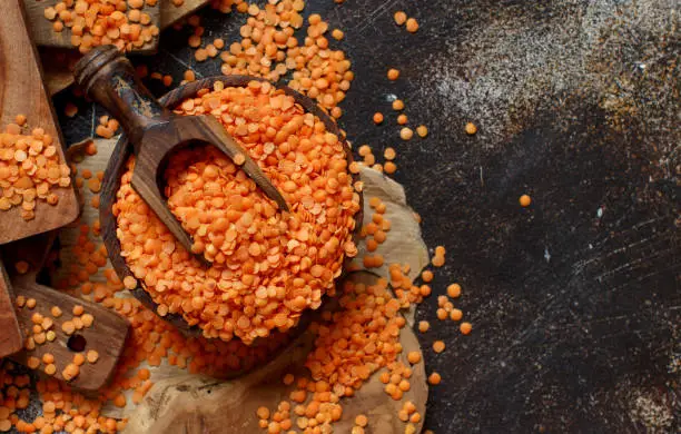 Red lentils in a bowl with a spoon top view