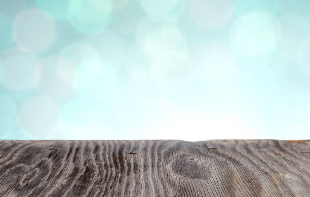istock Rrustic wood table in front of glitter and bright bokeh lights 1027359194