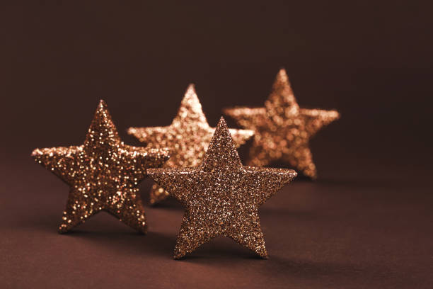 istock Golden sparkling stars on brown background 1027361686