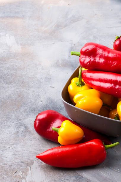 istock Sweet pepper is yellow and red, on a gray background. Free space for text, frame. Top view. 1027364668
